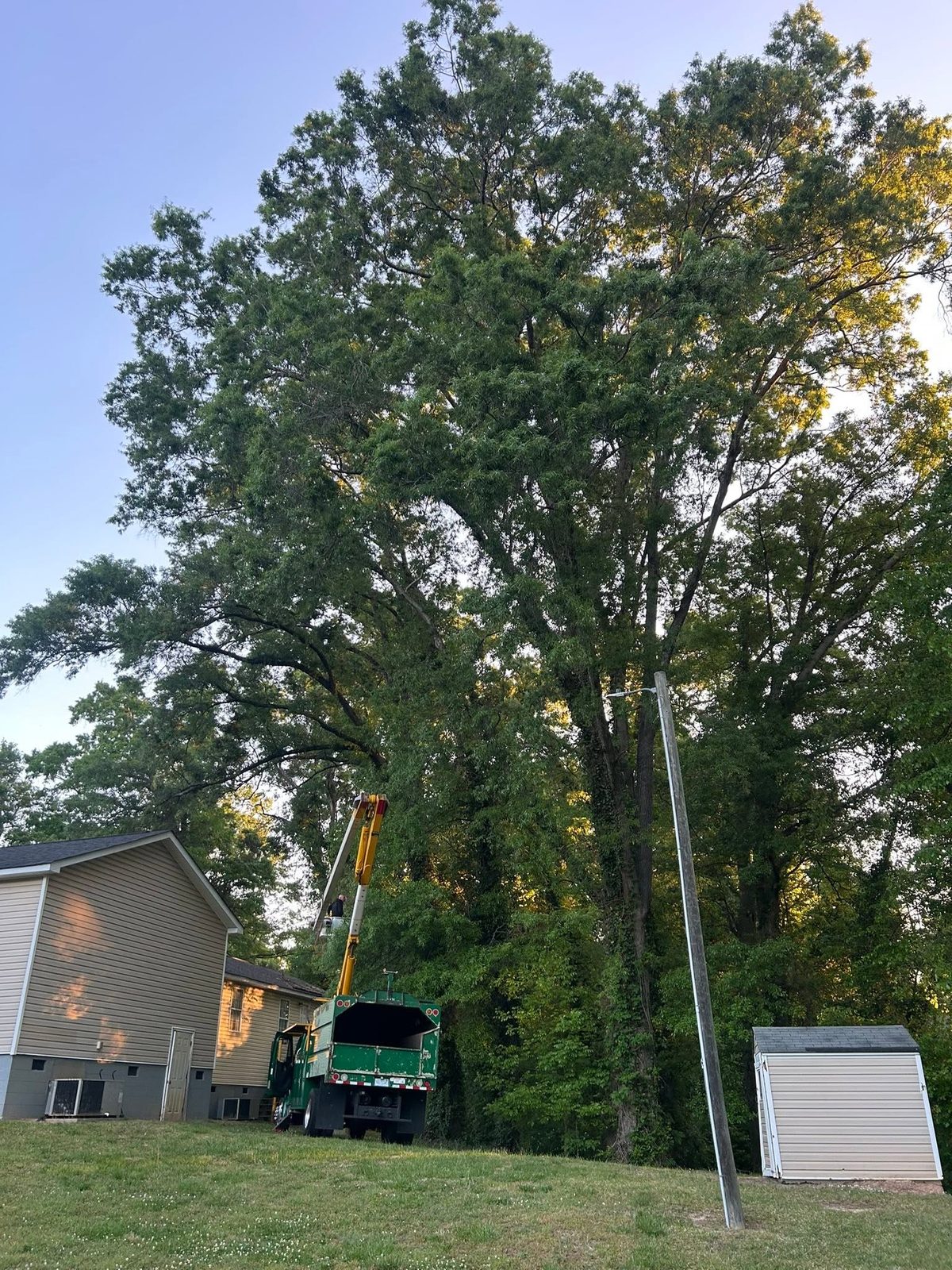 Bucket truck working beside a home